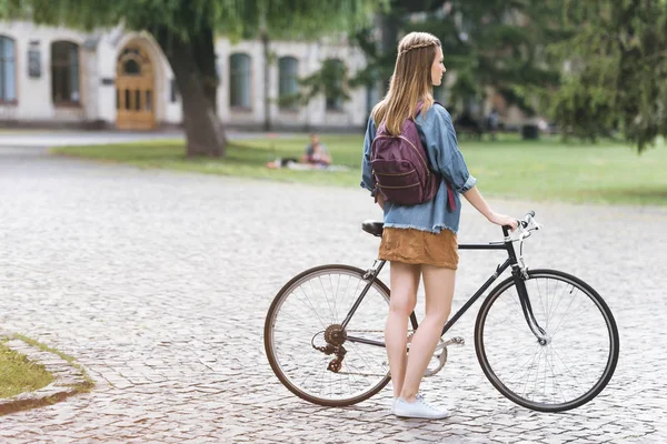 Mujer joven con bicicleta — Foto de Stock
