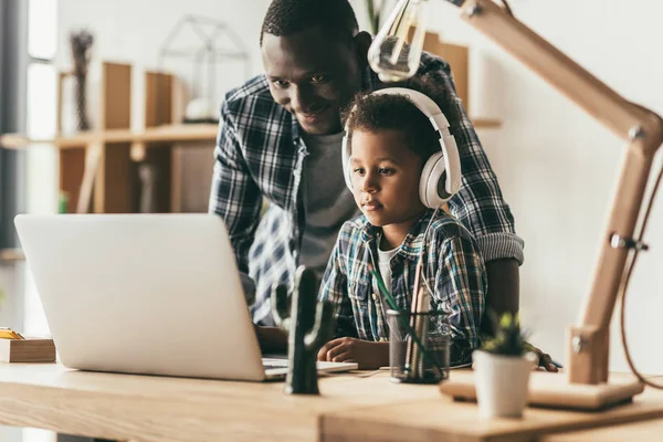 Baba ve oğul dizüstü bilgisayar kullanıyor.