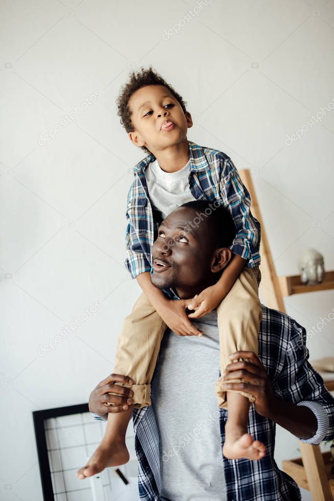 Beautiful little son piggybacking on father