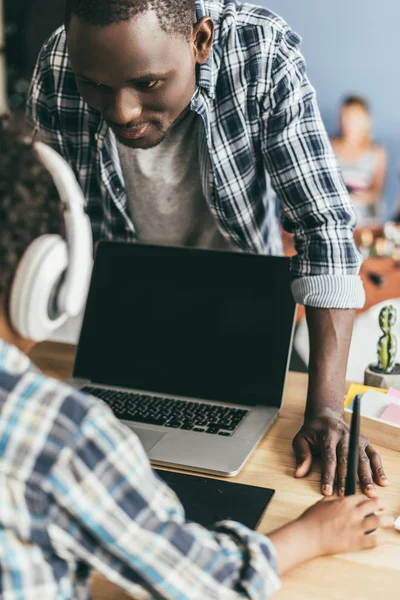 Father looking at son using laptop — Free Stock Photo