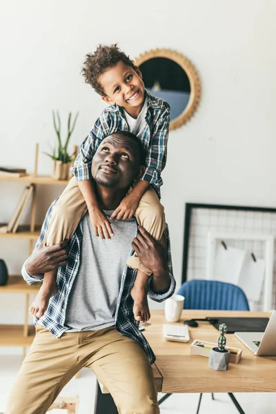 Bello figlio piggybacking su padre — Foto Stock