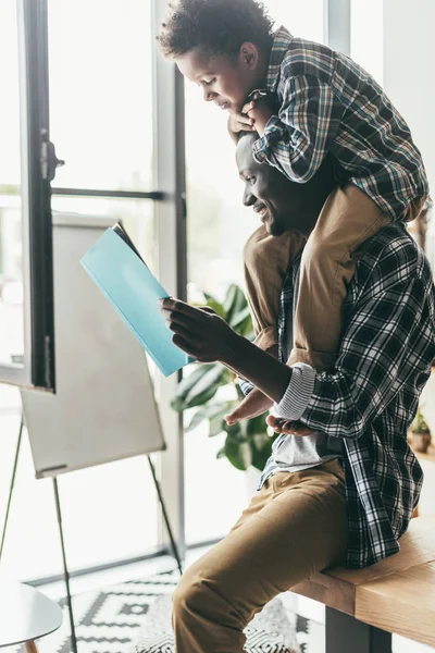 Filho piggybacking no trabalho pai — Fotos gratuitas