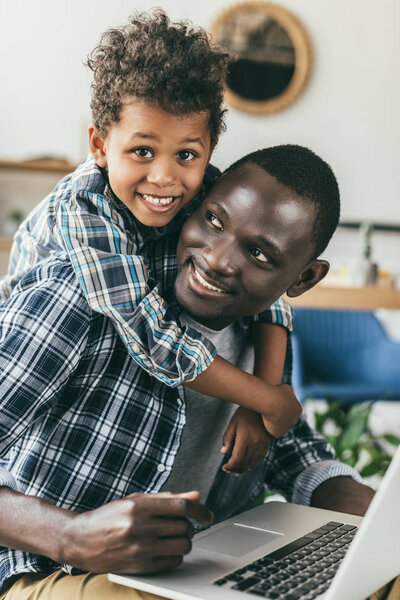 father spending time with son and working