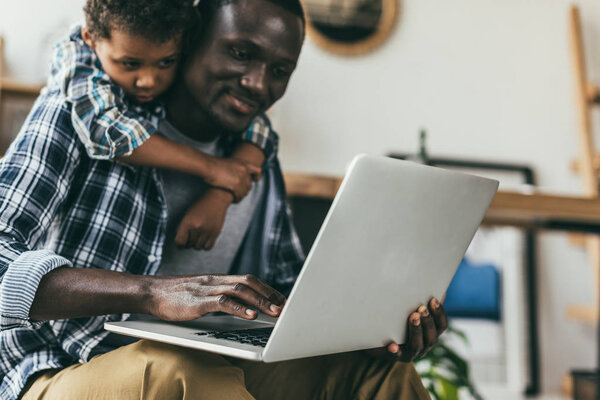 father spending time with son and working