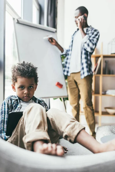 Bored boy sitting in armchair — Free Stock Photo