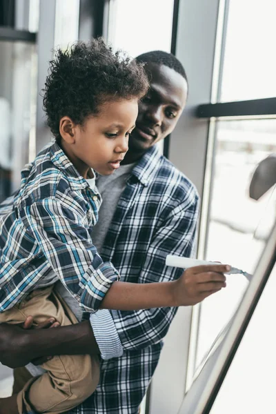 Afro-amerikansk far och son med whiteboard — Stockfoto