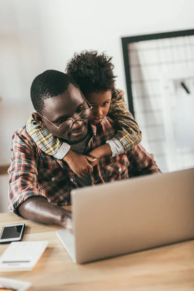 Père et fils utilisant un ordinateur portable dans le bureau — Photo gratuite