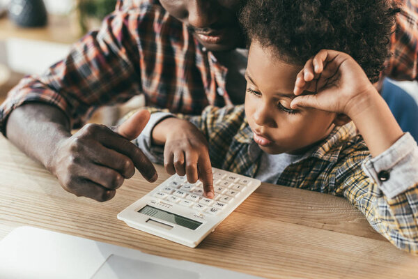father and son with calculator
