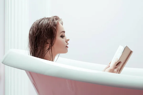 Frau liest Buch in Badewanne — Stockfoto