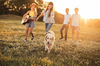 gençler ile parkta yürüyen köpek