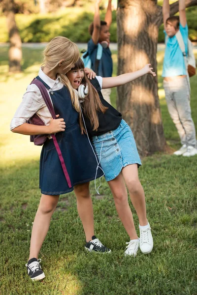 Schoolgirls with backpacks in park — Free Stock Photo