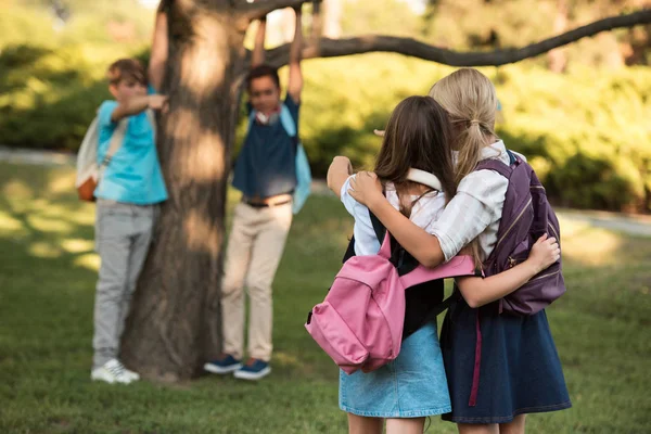 Schoolmeisjes met rugzakken in park — Stockfoto