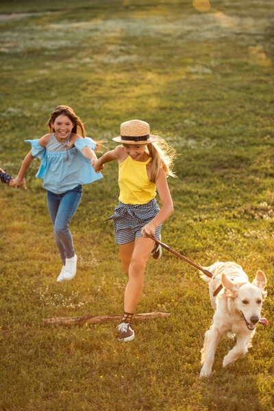 teenagers running with dog