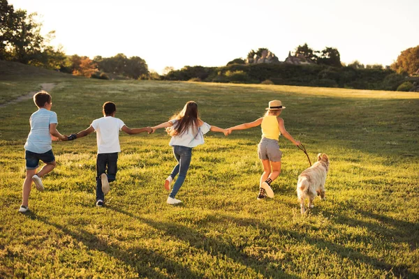 Teenagers with dog in park — Stock Photo, Image