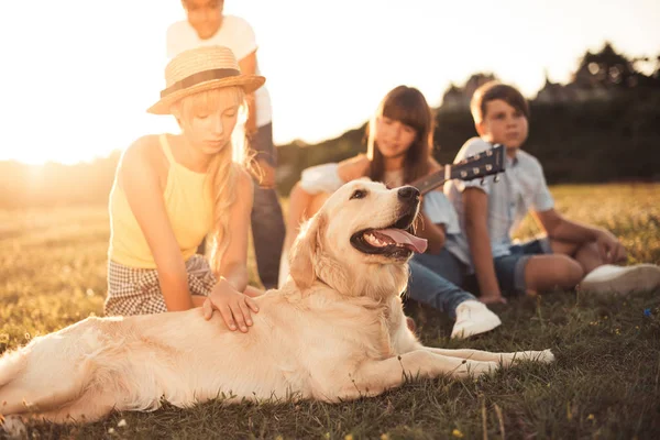 Teenagers with dog in park — Stock Photo, Image