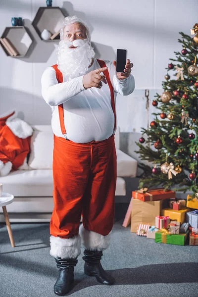 Santa claus pointing at smartphone — Stock Photo, Image