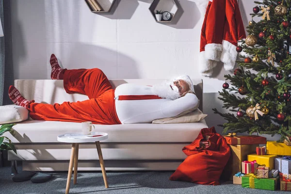 Santa claus odpoczynku na kanapie — Zdjęcie stockowe