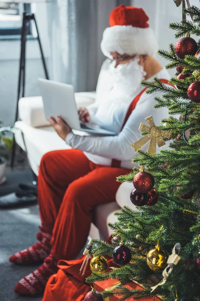 Санта-Клаус с помощью ноутбука — Бесплатное стоковое фото
