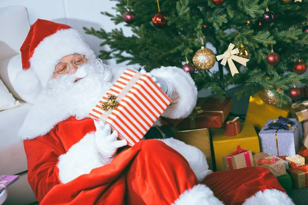 Santa claus with gift — Free Stock Photo