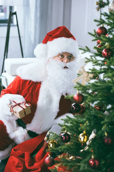 Santa claus with christmas gift — Free Stock Photo