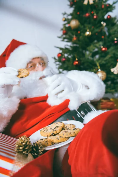 Santa claus eten cookies — Stockfoto