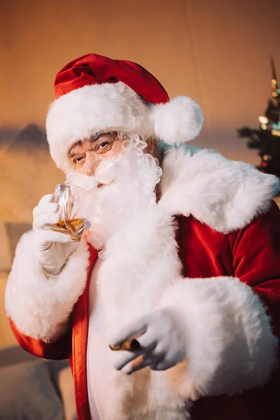 Санта Клаус со стаканом виски и сигарой — стоковое фото