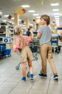 çocuklar süpermarkette alışveriş sepeti ile