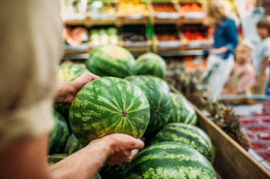 woman picking watermelon in grocery shop clipart