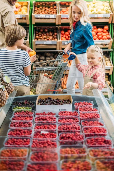 Família que escolhe bagas em supermercado — Fotografia de Stock