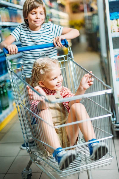 Anak-anak dengan keranjang belanja di supermarket — Stok Foto