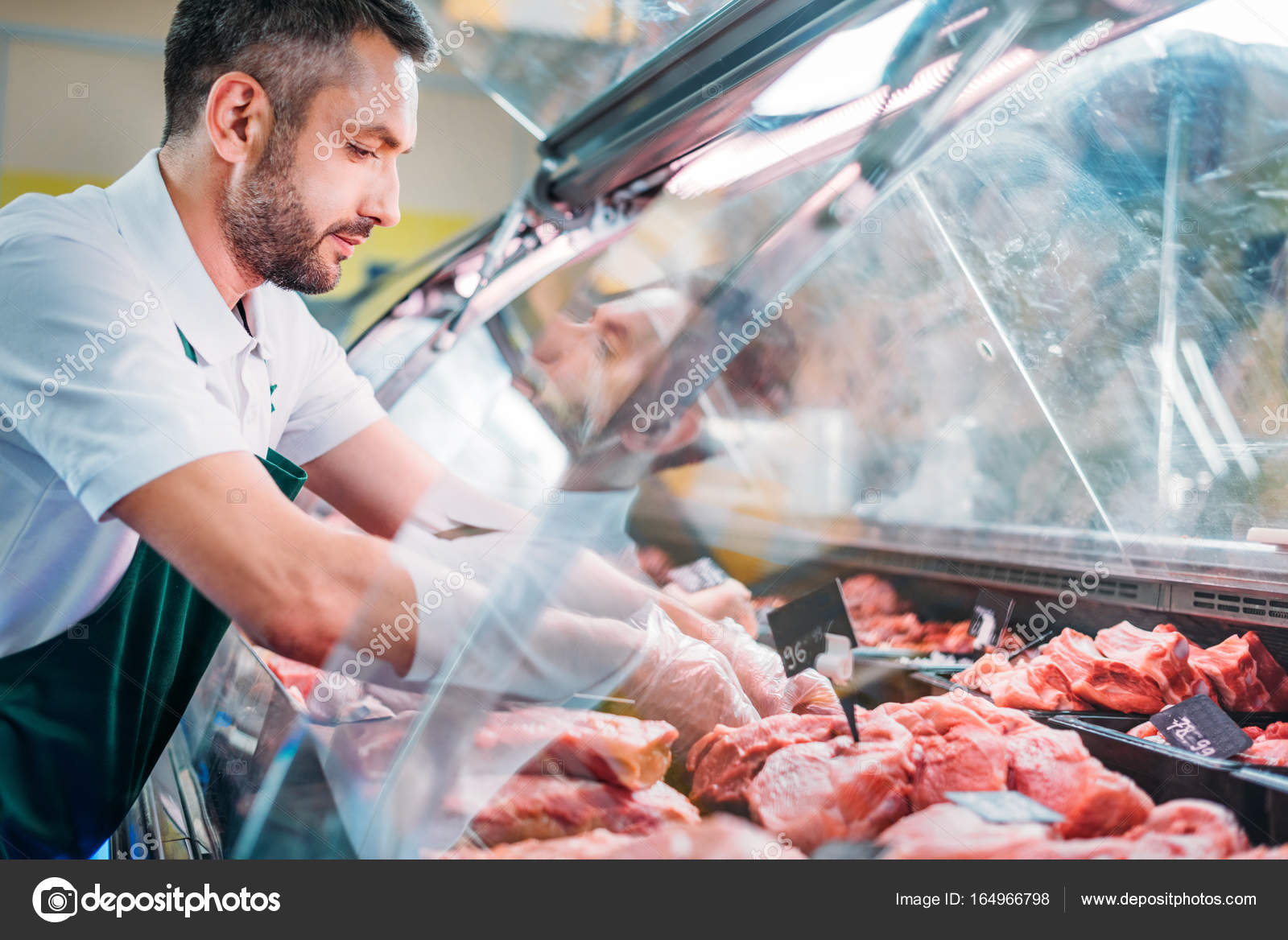 Shop assistant assorting raw meat — Stock Photo © ArturVerkhovetskiy
