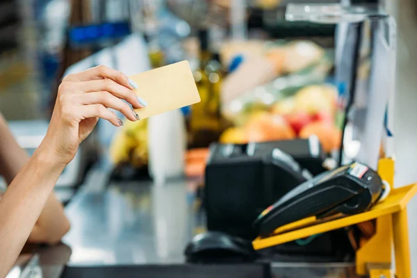 Асистент магазину тримає кредитну картку — стокове фото