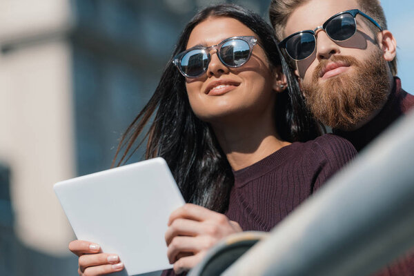 Молодая пара с планшетом на открытом воздухе
