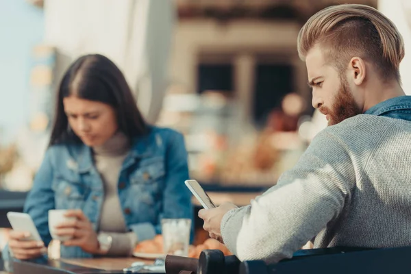 Coppia guardando smartphone in caffè — Foto Stock