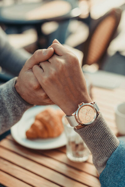 couple holding hands in cafe