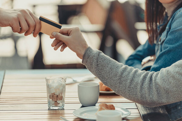 couple paying with credit card in cafe