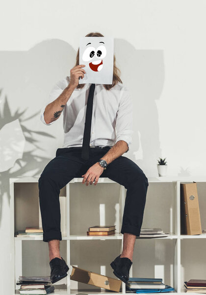 business man holding card with funny face
