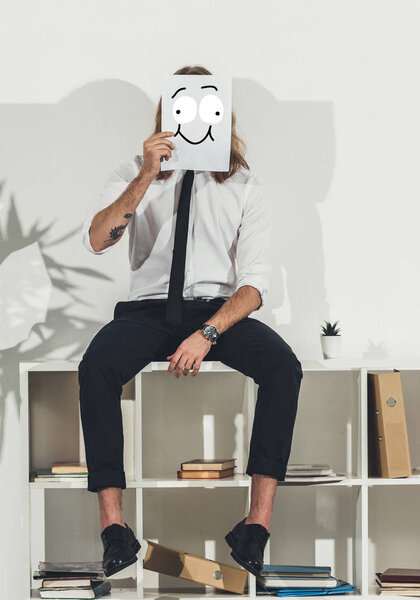 business man holding card with funny face
