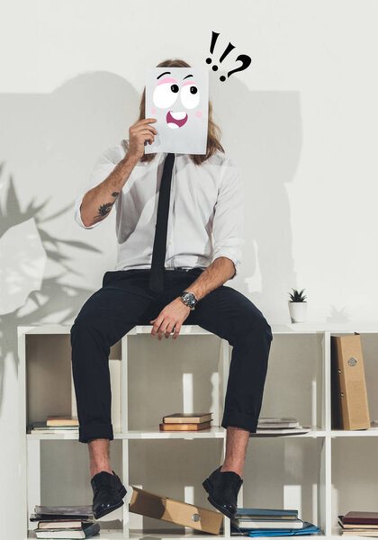 business man holding card with funny face
