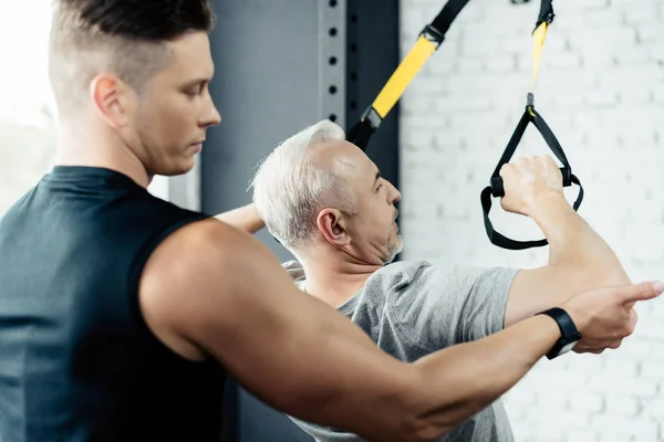 Entrenamiento de deportista con trx y entrenador — Foto de Stock