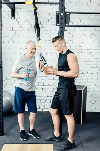 Senior sportsman talking with trainer — Stock Photo, Image