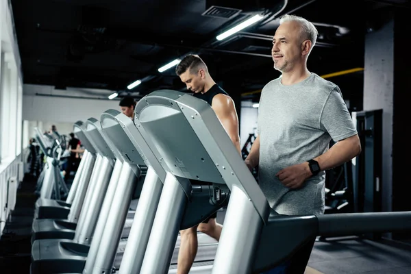 Sportsmen running on treadmills — Stock Photo, Image