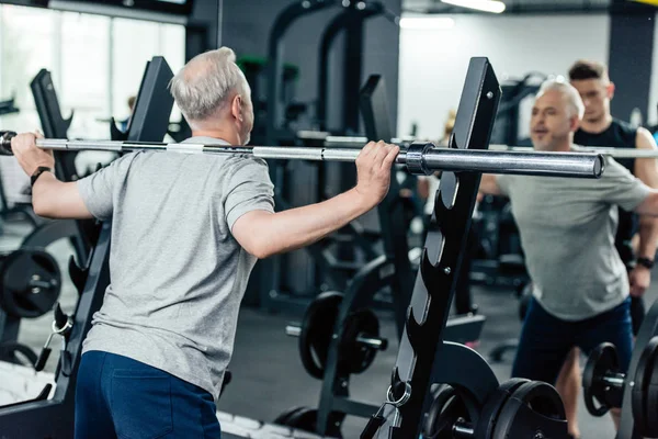 Senior sportman hijs barbell — Stockfoto