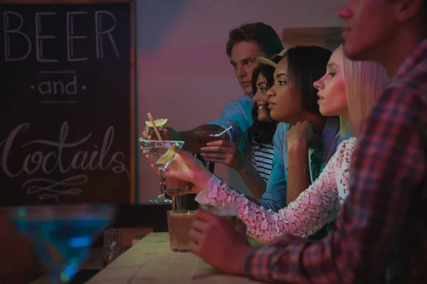 Amigos multiétnicos beber cócteles en el bar — Foto de stock gratis