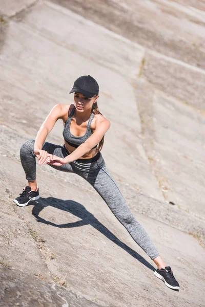 Woman stretching on slabs — Stock Photo, Image