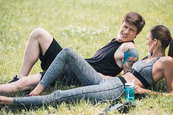 Sportive couple resting in park — Stock Photo, Image