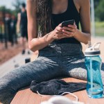 Sportive woman using smartphone