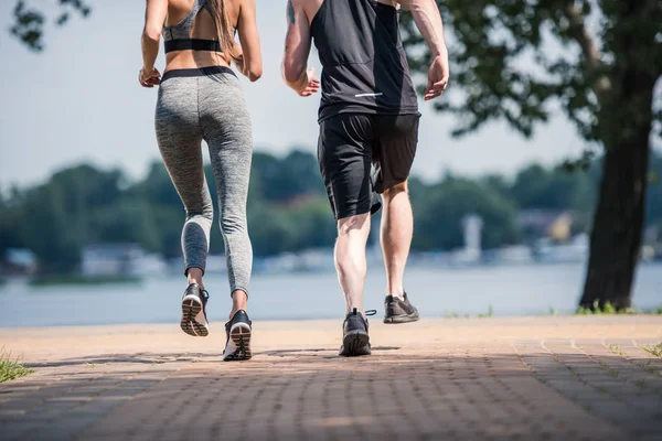 Sportovní dvojice běhání v parku — Stock fotografie
