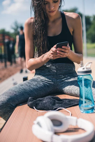 Sportive woman using smartphone — Free Stock Photo