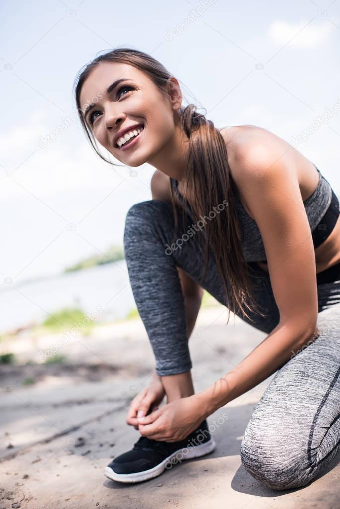 athletic woman tying shoelaces